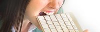 Frau beisst in eine Tastatur